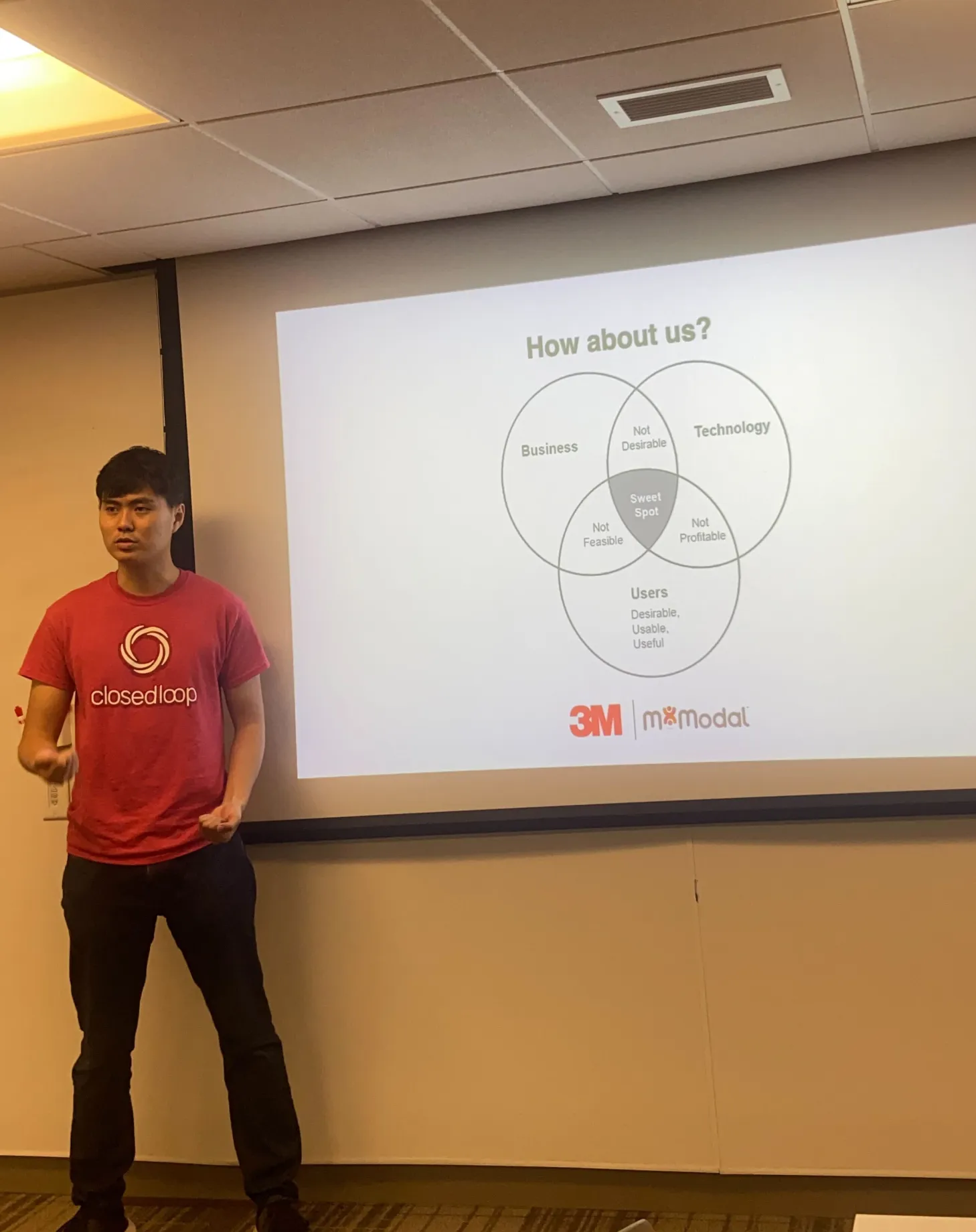 Lawrence presenting an internal design advocacy talk at 3M, in front of a slide about balancing business, technology, and users